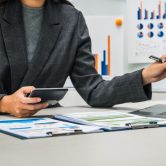 businesswoman works diligently at her desk, reviewing financial documents and analyzing investment